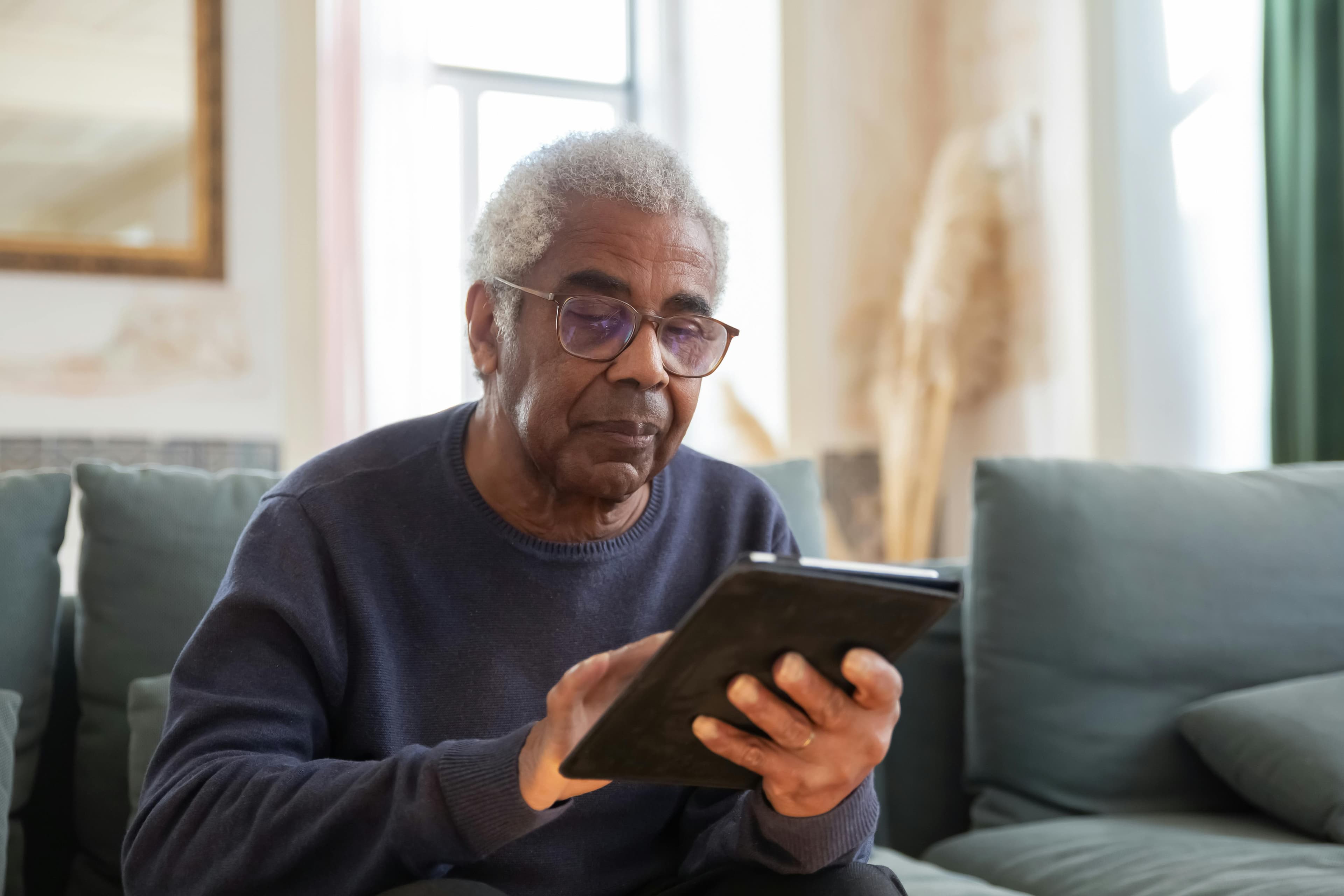 Reading the day's visit note on a tablet at home